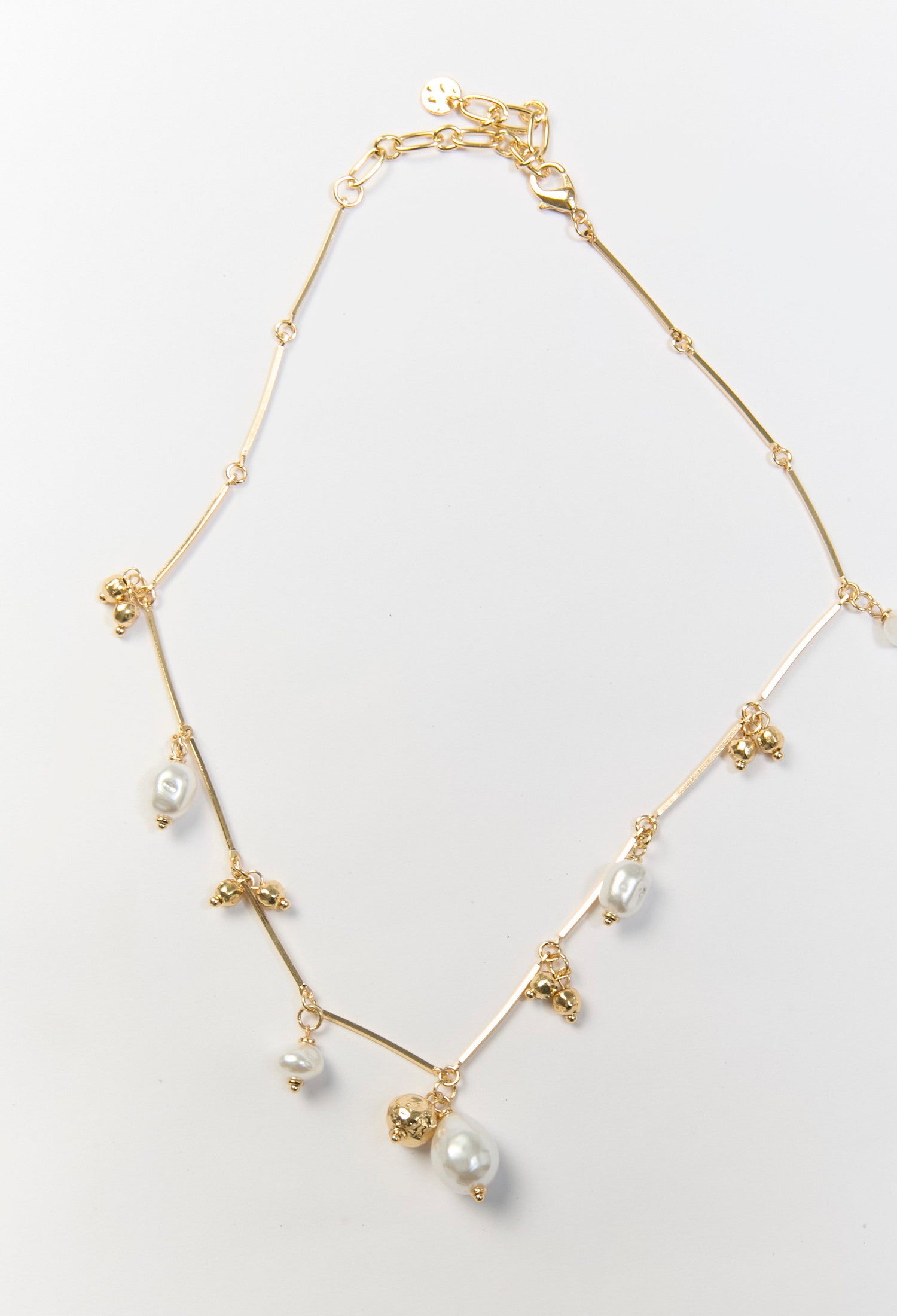 Collar dorado con multiples dijes y perla sintetica central