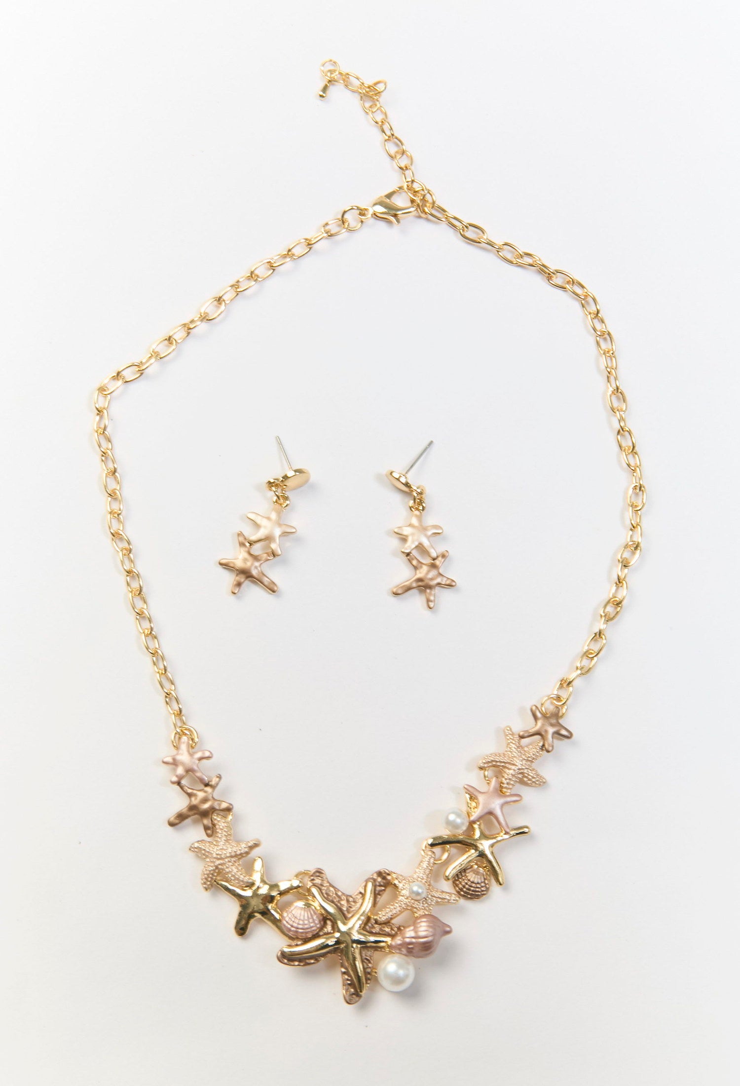 Set de collar y aretes dorados con estrellas de mar metálicas y perlas sinteticas