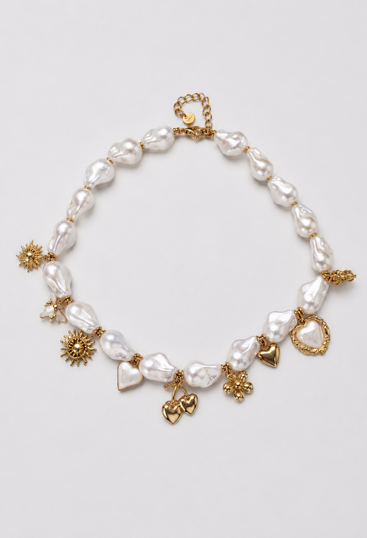 Collar corto de perlas barrocas con dijes dorados de corazones y flores