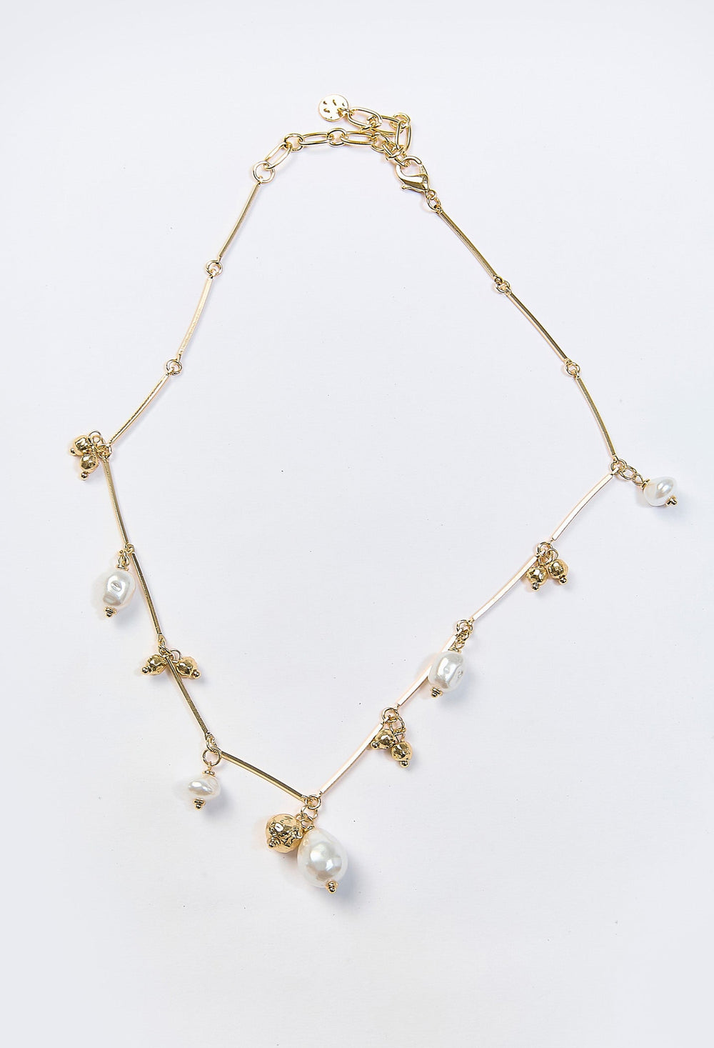 Collar dorado con multiples dijes y perla sintetica central