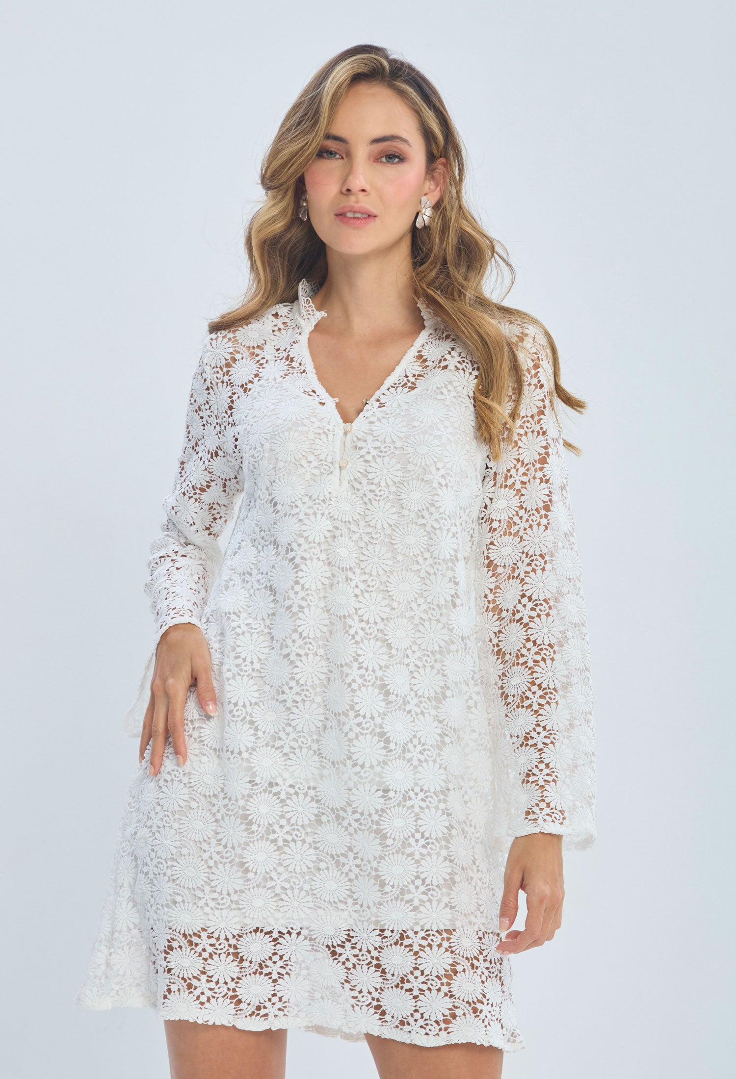 Woman wearing a white floral lace long sleeve dress, modern feminine fashion