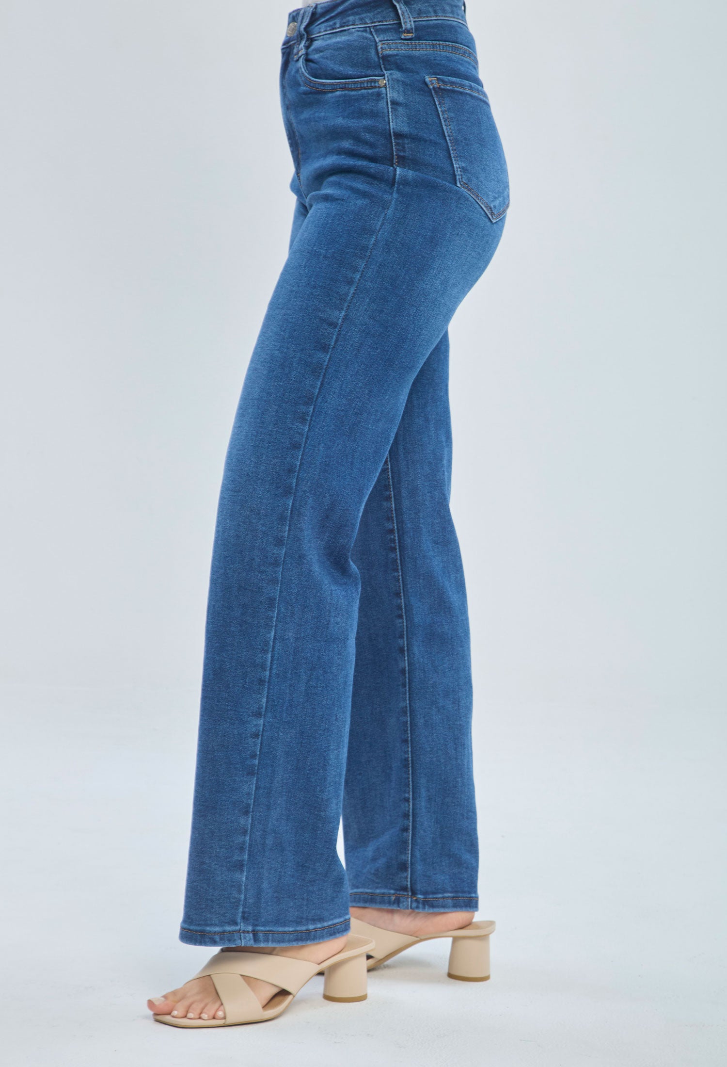 Woman wearing high-waisted blue straight leg jeans and nude heeled sandals