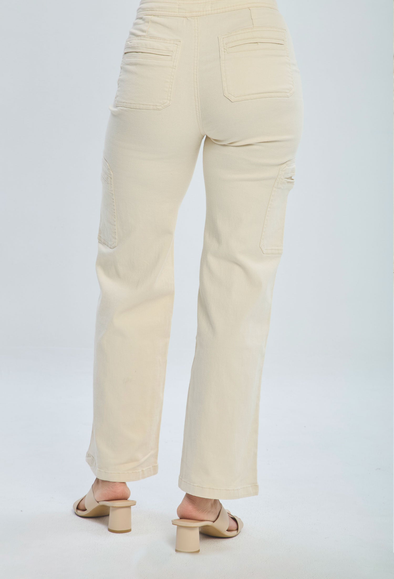Back view of woman wearing high waisted cream straight-leg pants with patch pockets