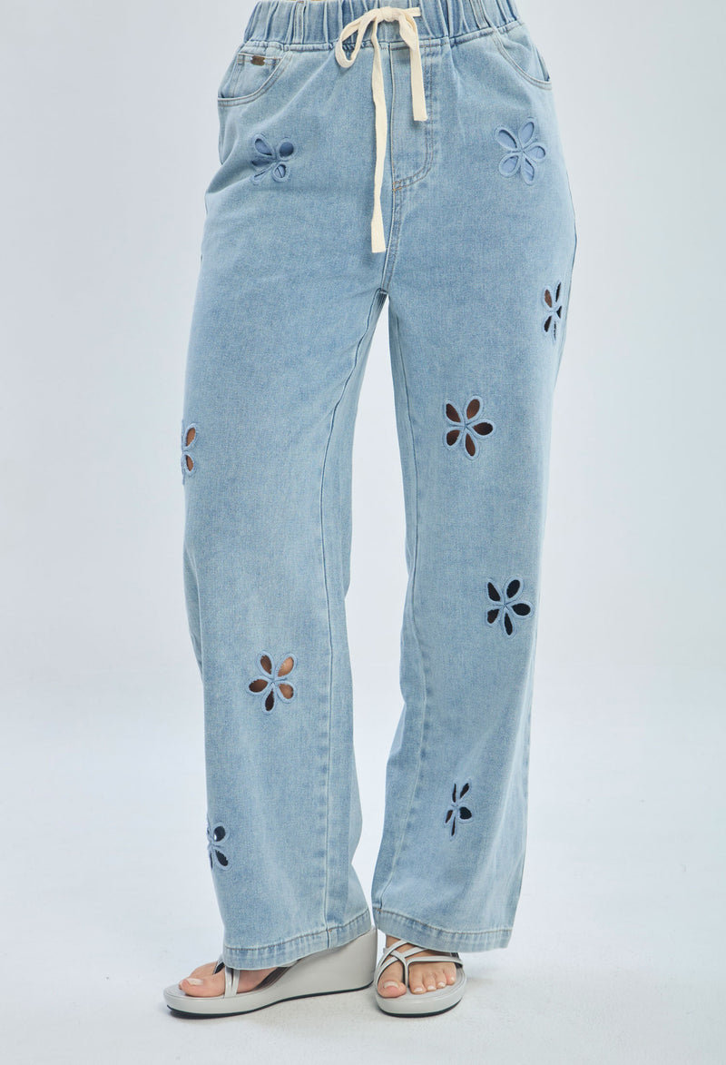 Light blue denim pants with floral cutouts, drawstring waist, and wide leg fit for women