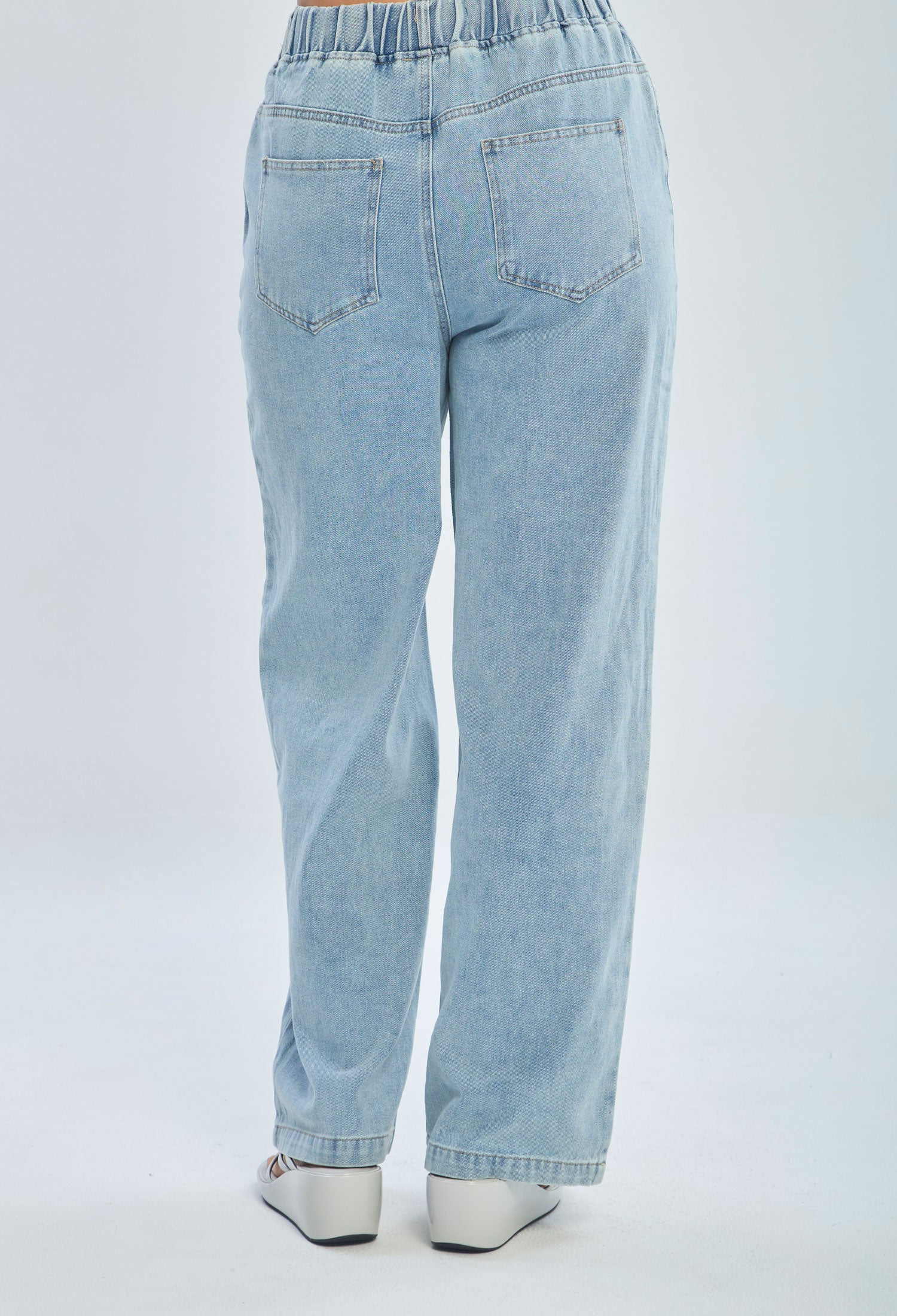Women's light blue high-waisted straight leg jeans with elastic waistband, back view