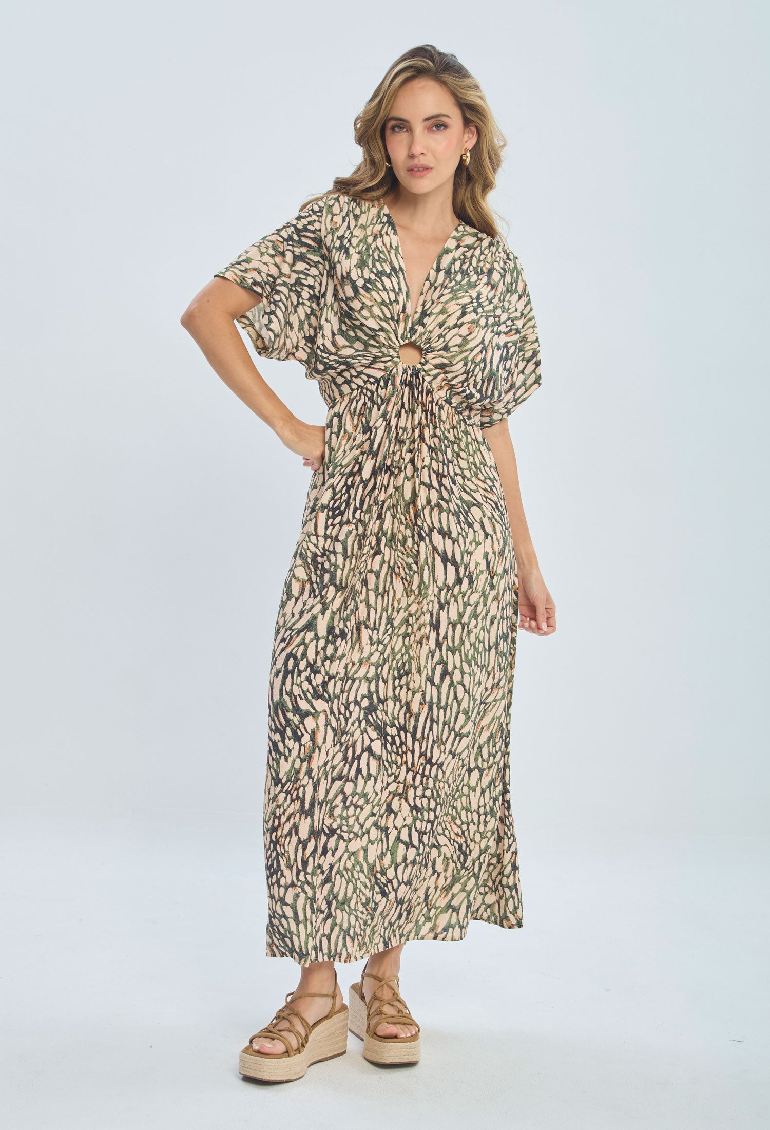 Woman wearing a printed maxi dress with knotted front and short sleeves, platform sandals
