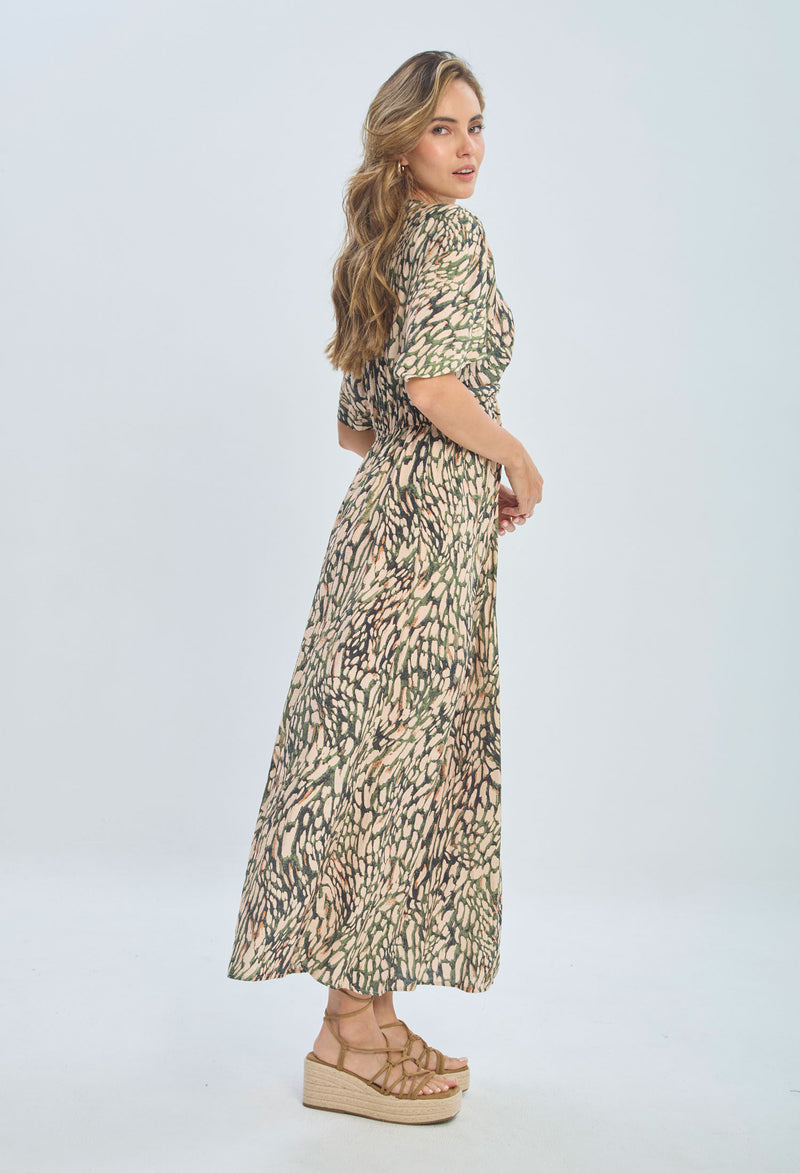 Woman wearing a patterned maxi dress with short sleeves and platform sandals