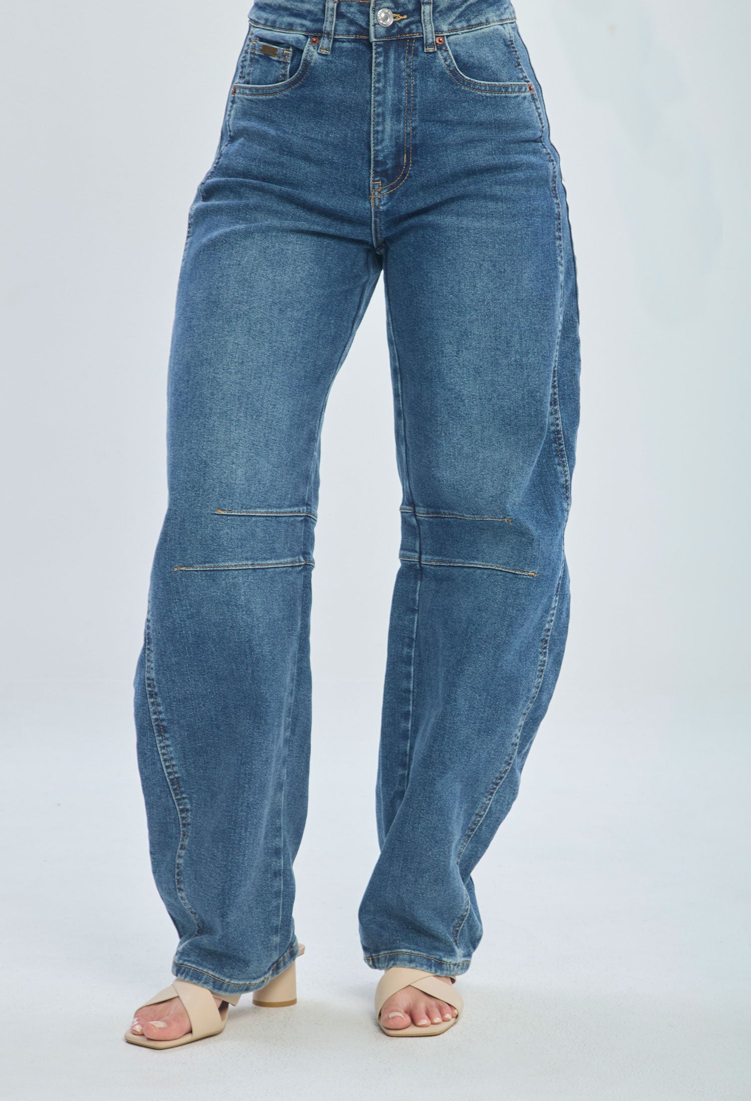 High-waisted wide leg blue jeans with seam details, styled with beige heeled sandals