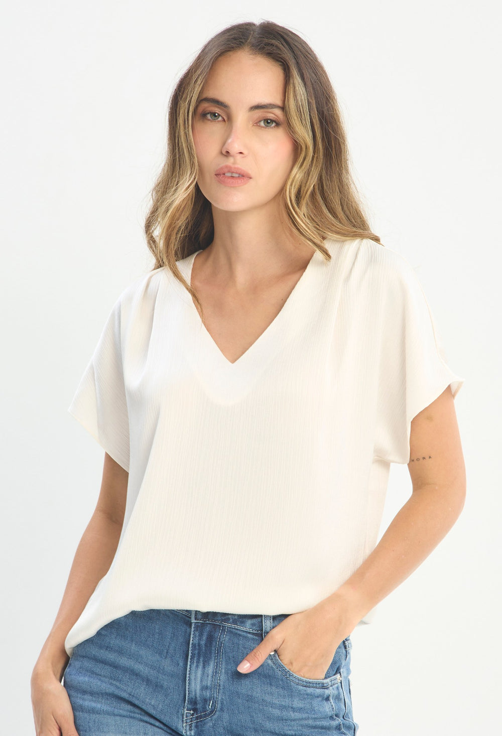Mujer luciendo blusa beige BYBLA - Escote V Satín
