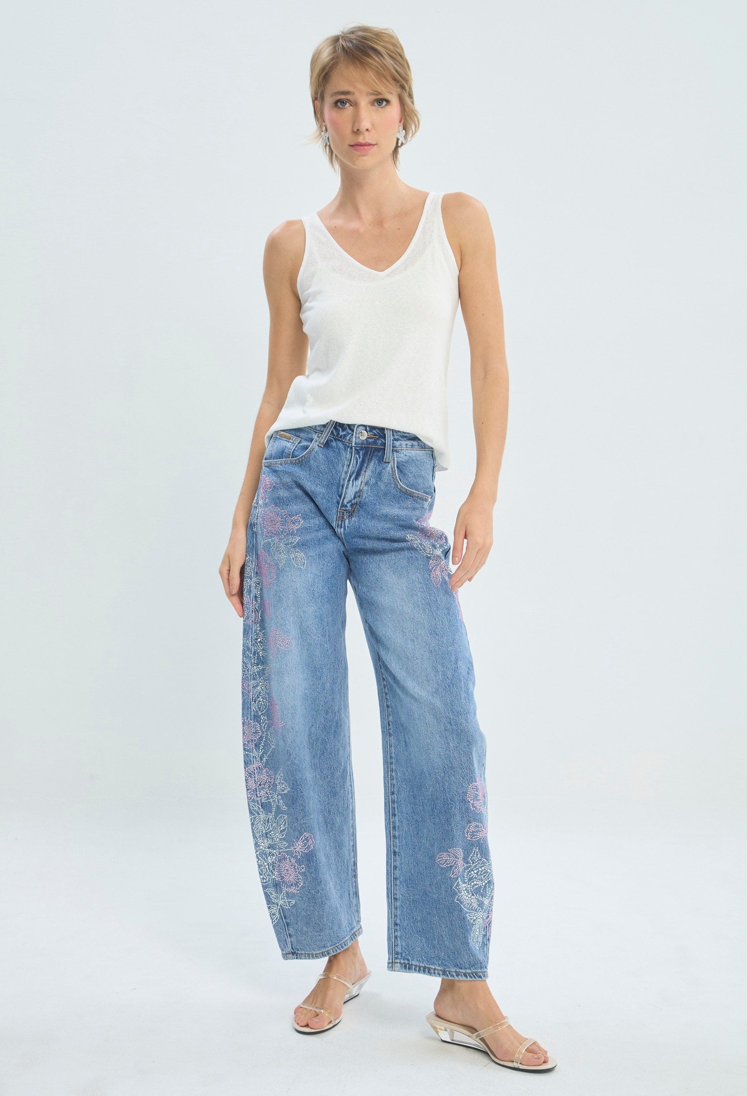 Jean barrel azul con flores en pedrería rosa y plateada en los laterales