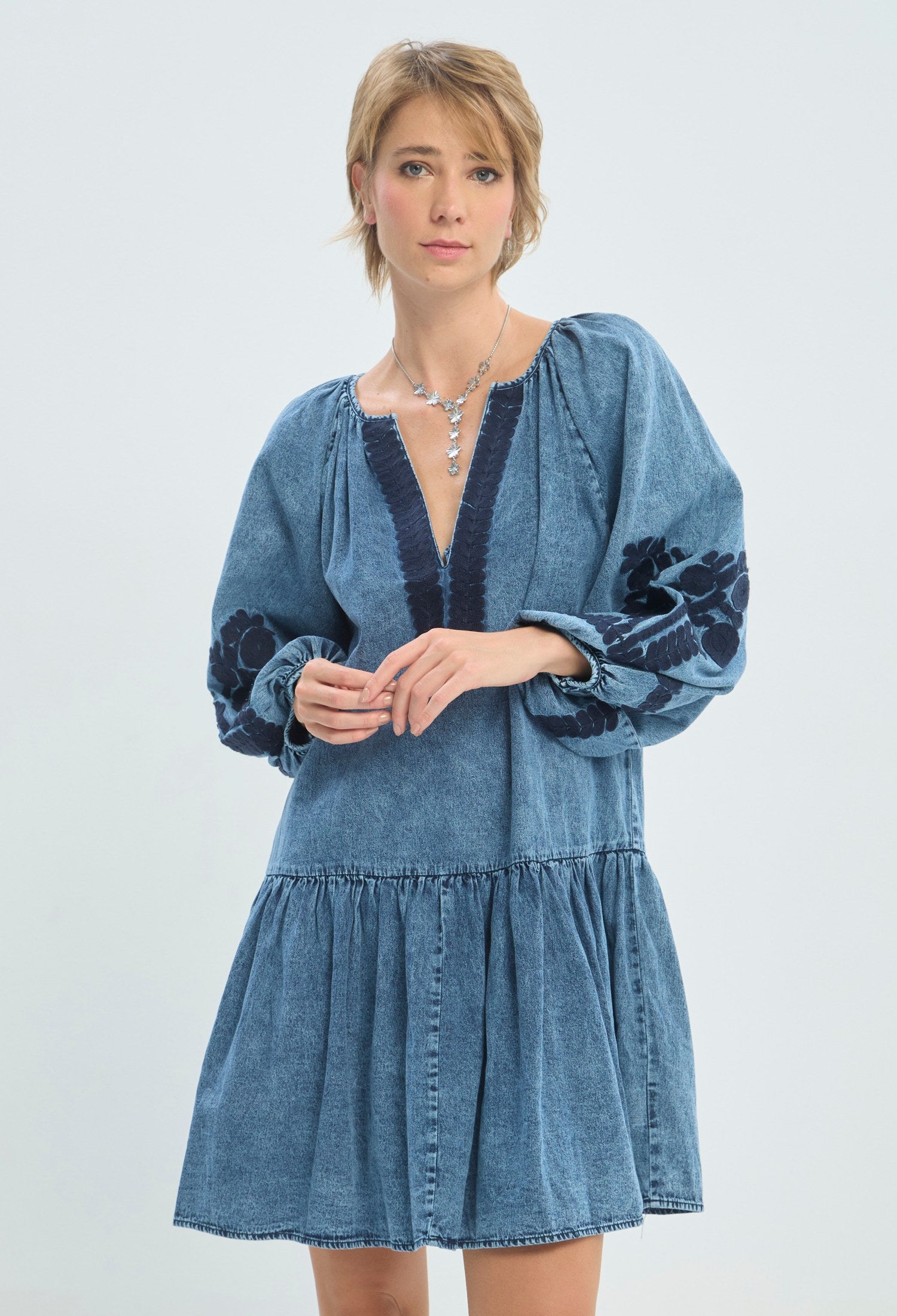 Vestido corto en denim azul con bordados florales y mangas bombachas BYBLA