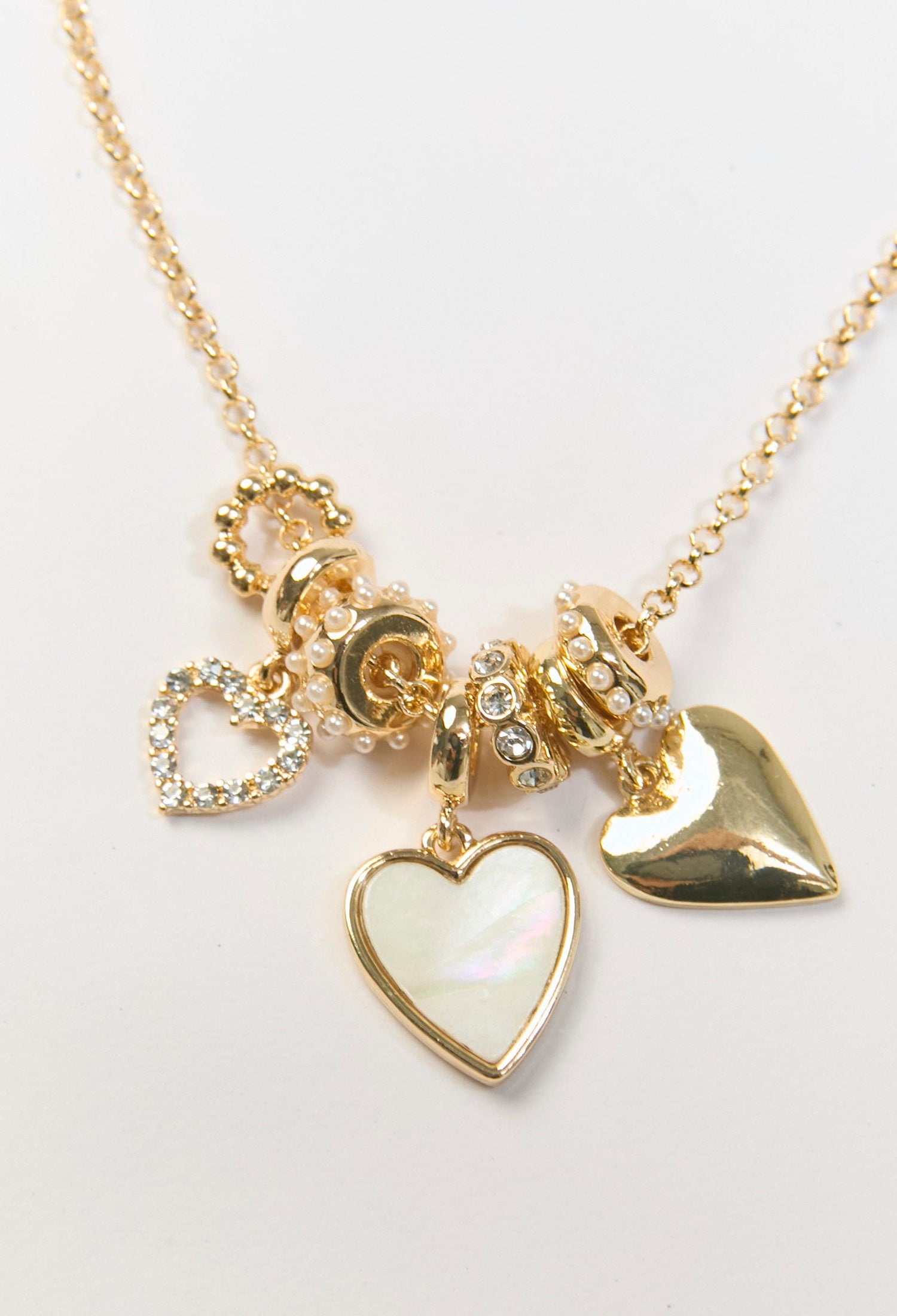 Collar dorado con multiples dijes de corazon metálicos de distintos tamaños - vista 3