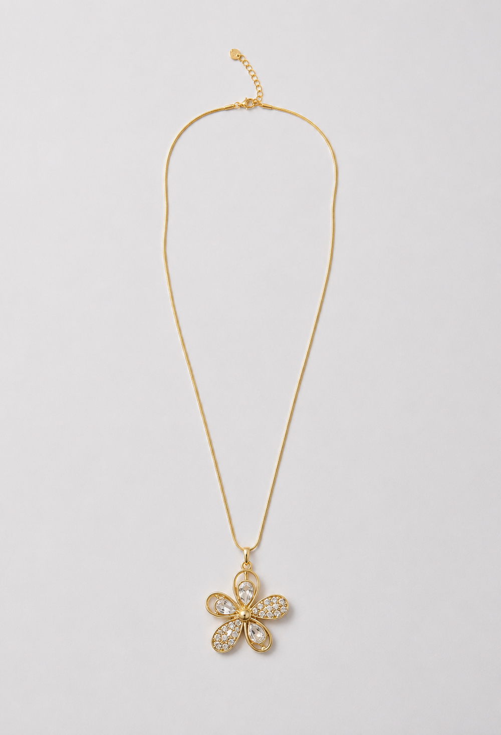 Collar dorado con dije de flor en cristales tallados y pavé