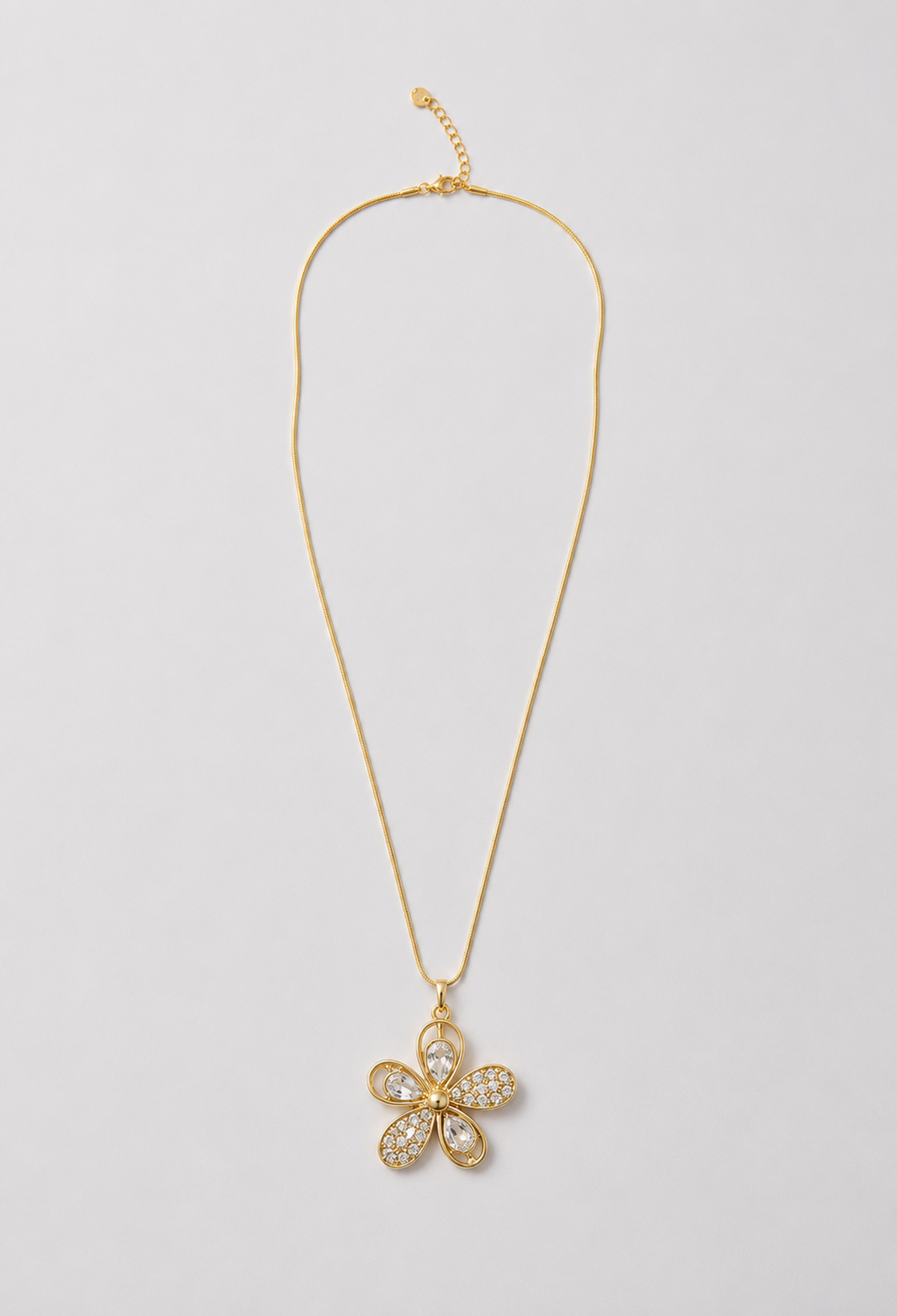 Collar dorado con dije de flor en cristales tallados y pavé