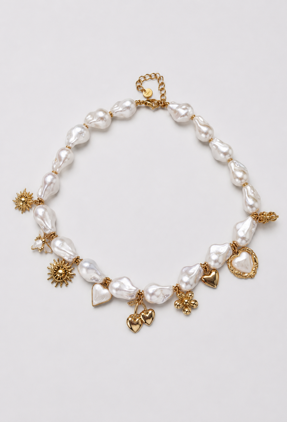 Collar corto de perlas barrocas con dijes dorados de corazones y flores