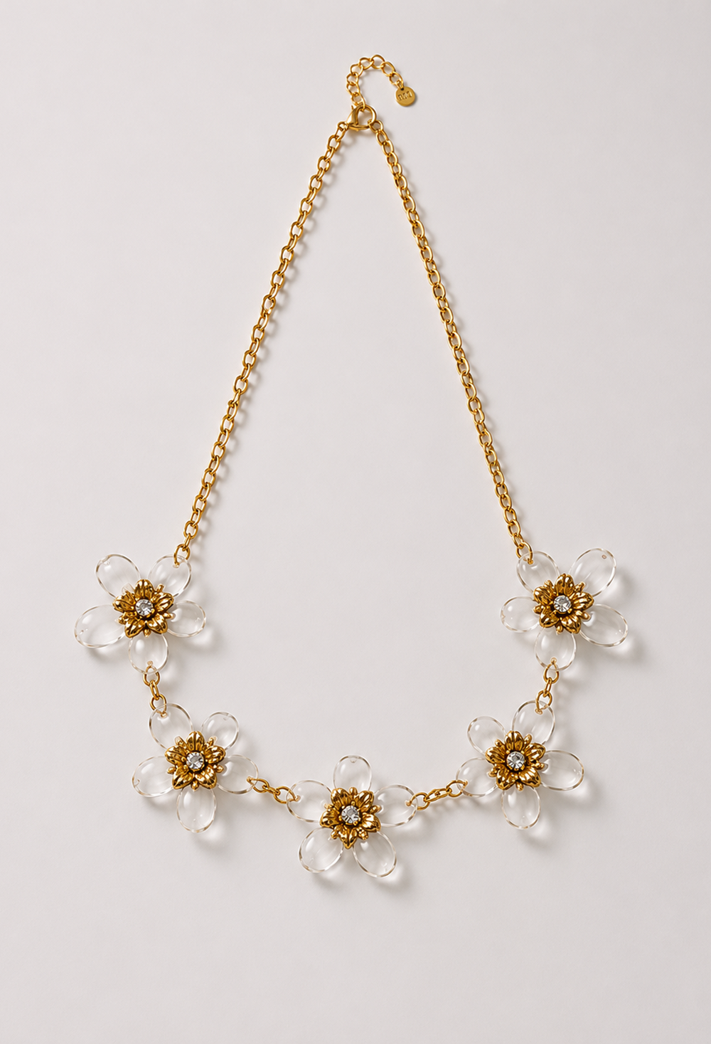Collar de cadena dorada con cinco flores de pétalos transparentes y centro dorado