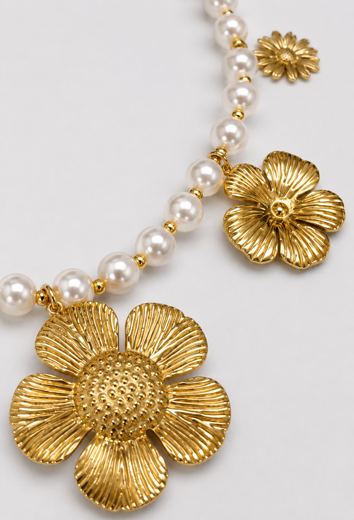 Collar de perlas blancas con cinco flores doradas de diseños distintos - vista 2
