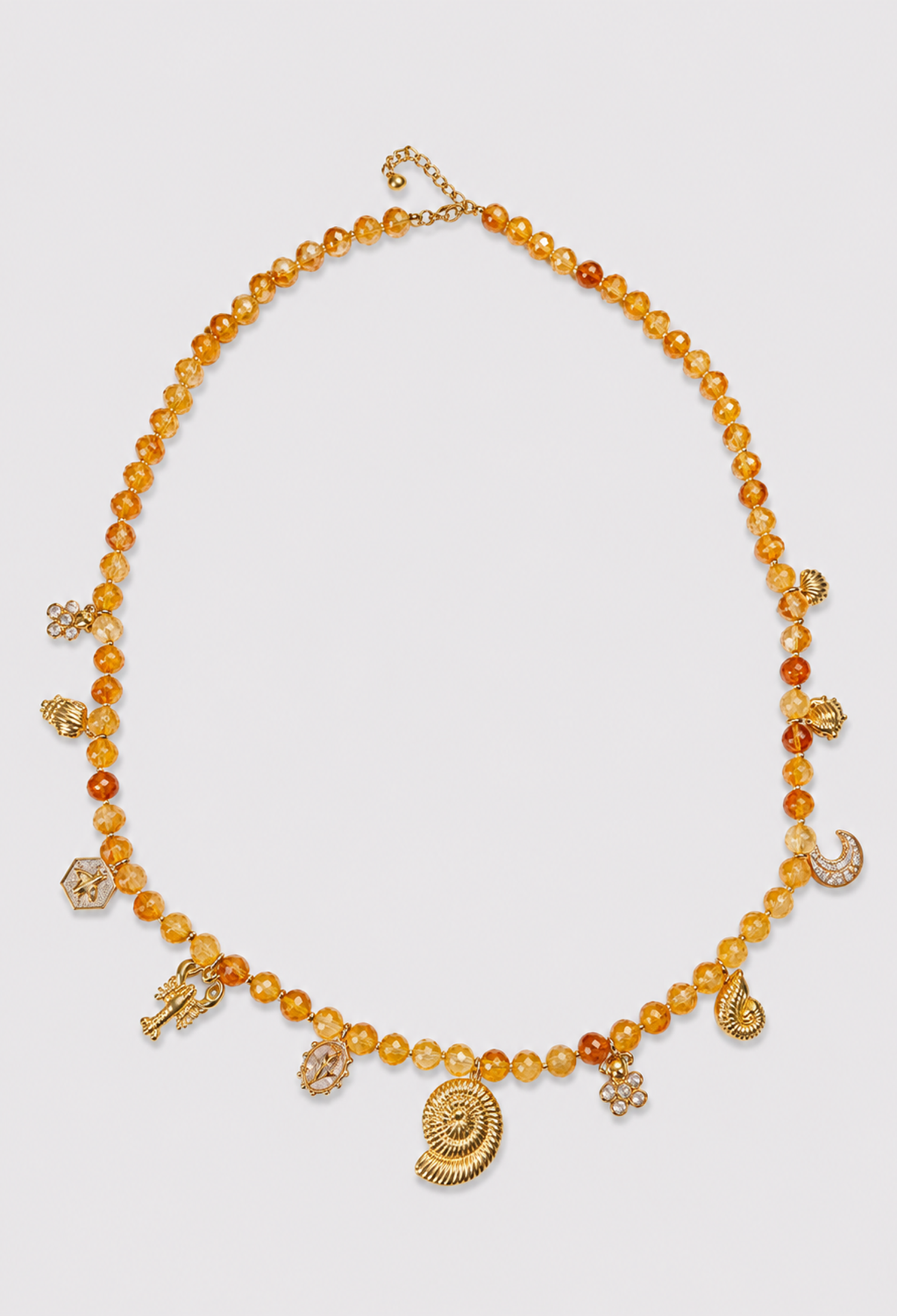 Collar largo de cuentas con dijes dorados de caracola, luna y conchas - Dorados