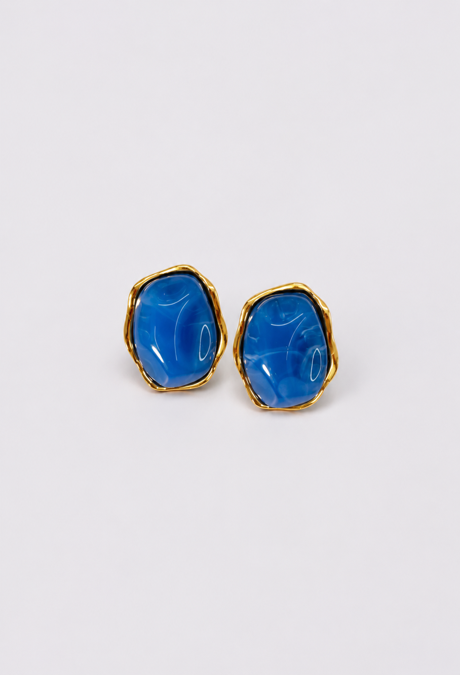 Aretes piedra orgánica azul con borde dorado BYBLA