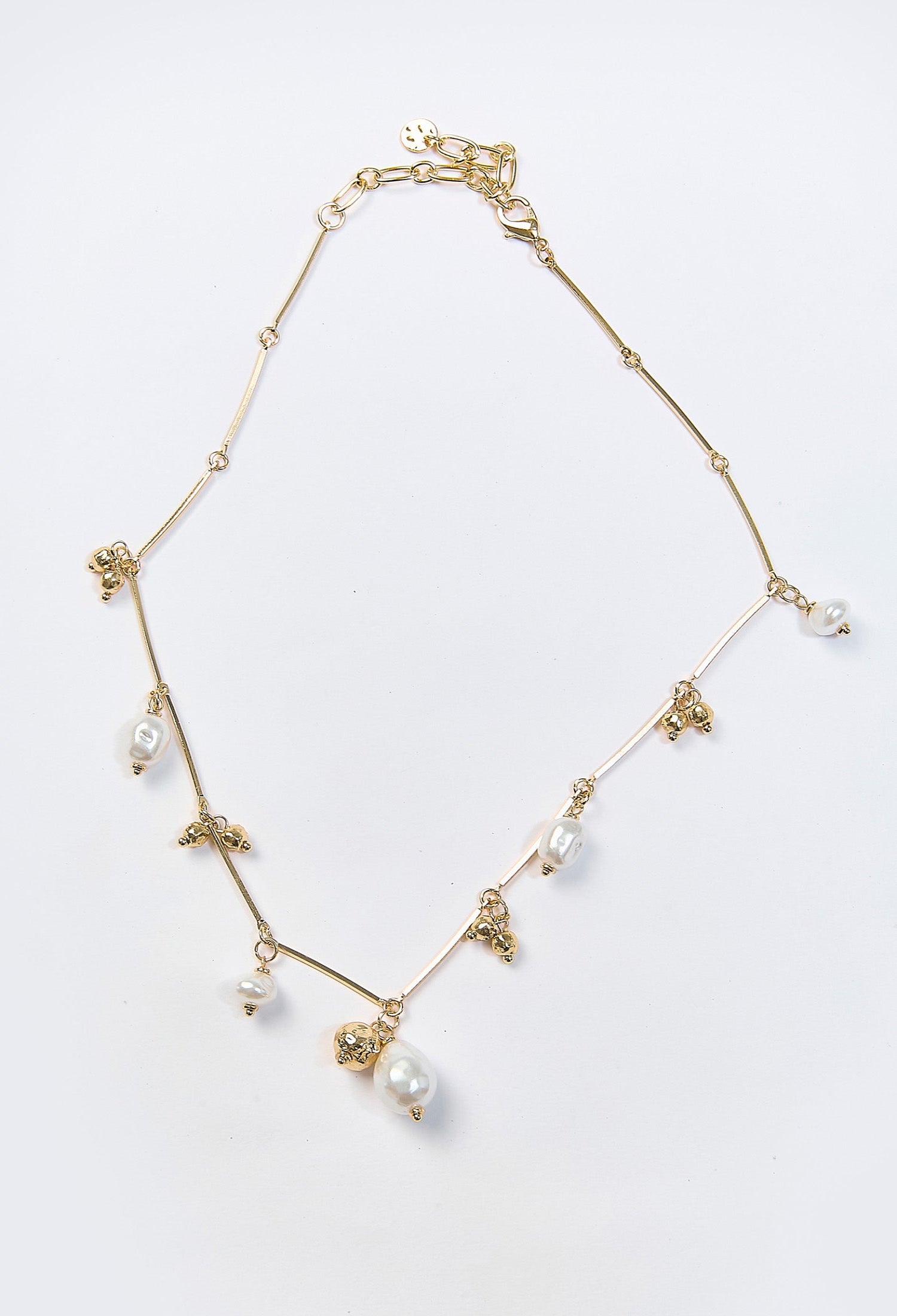 Collar dorado con multiples dijes y perla sintetica central