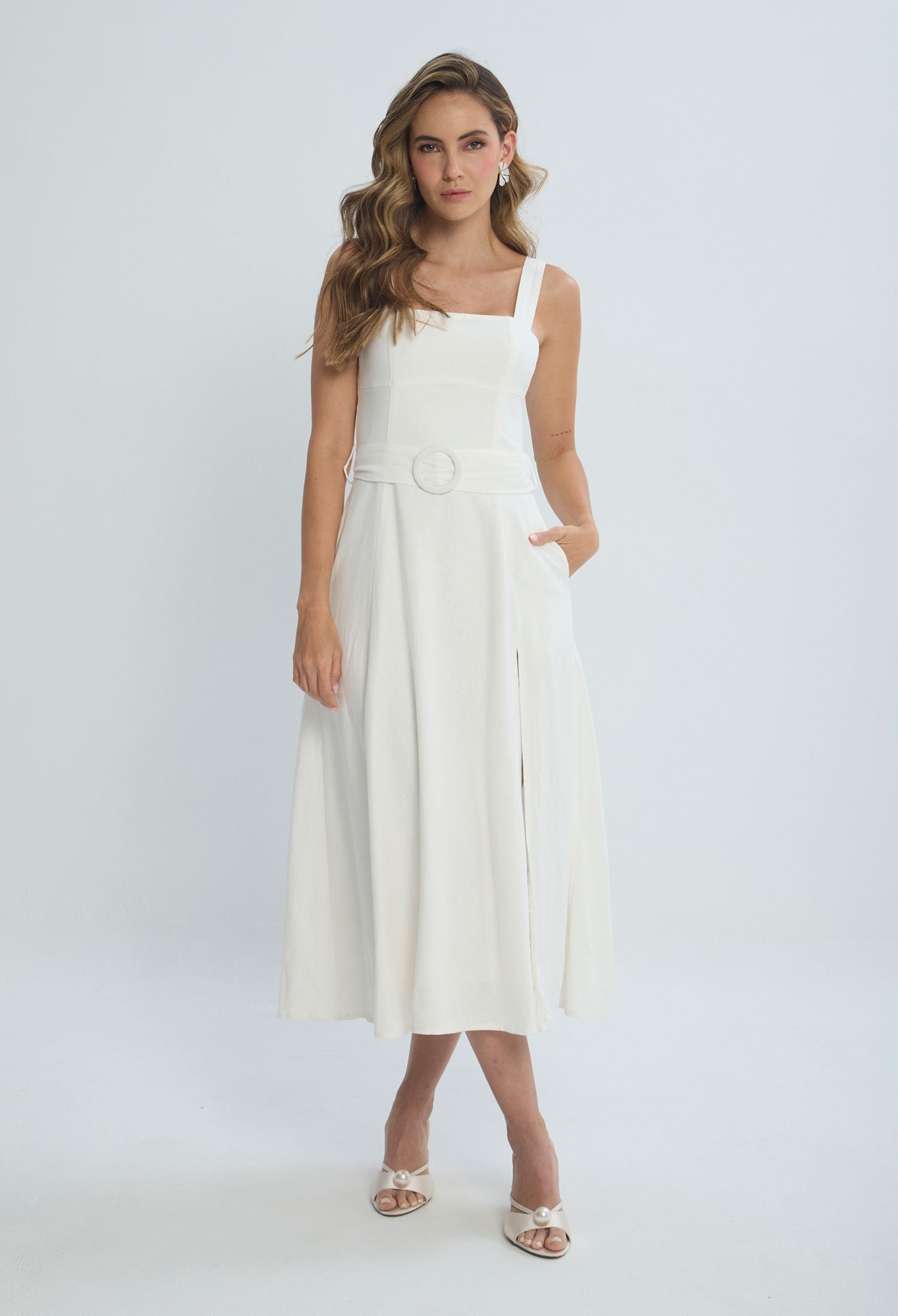 Woman wearing elegant white sleeveless belted midi dress with slit, fashion trend