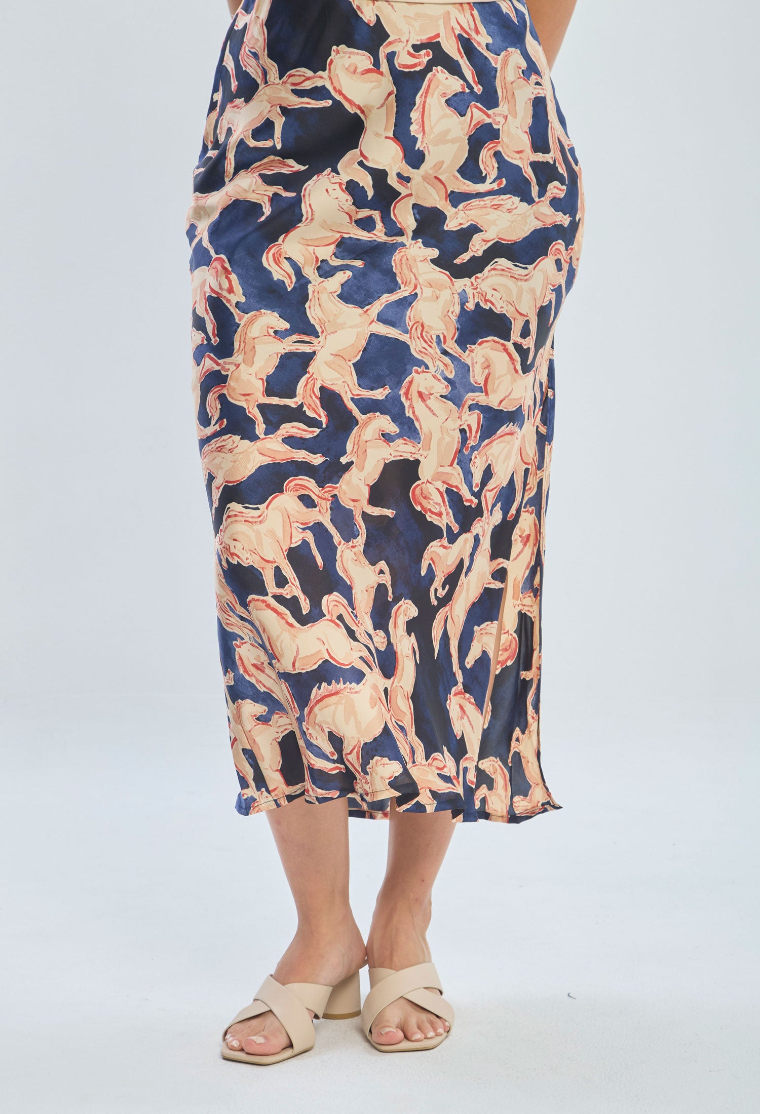 Women's midi skirt with horse print in beige and blue, paired with beige sandals