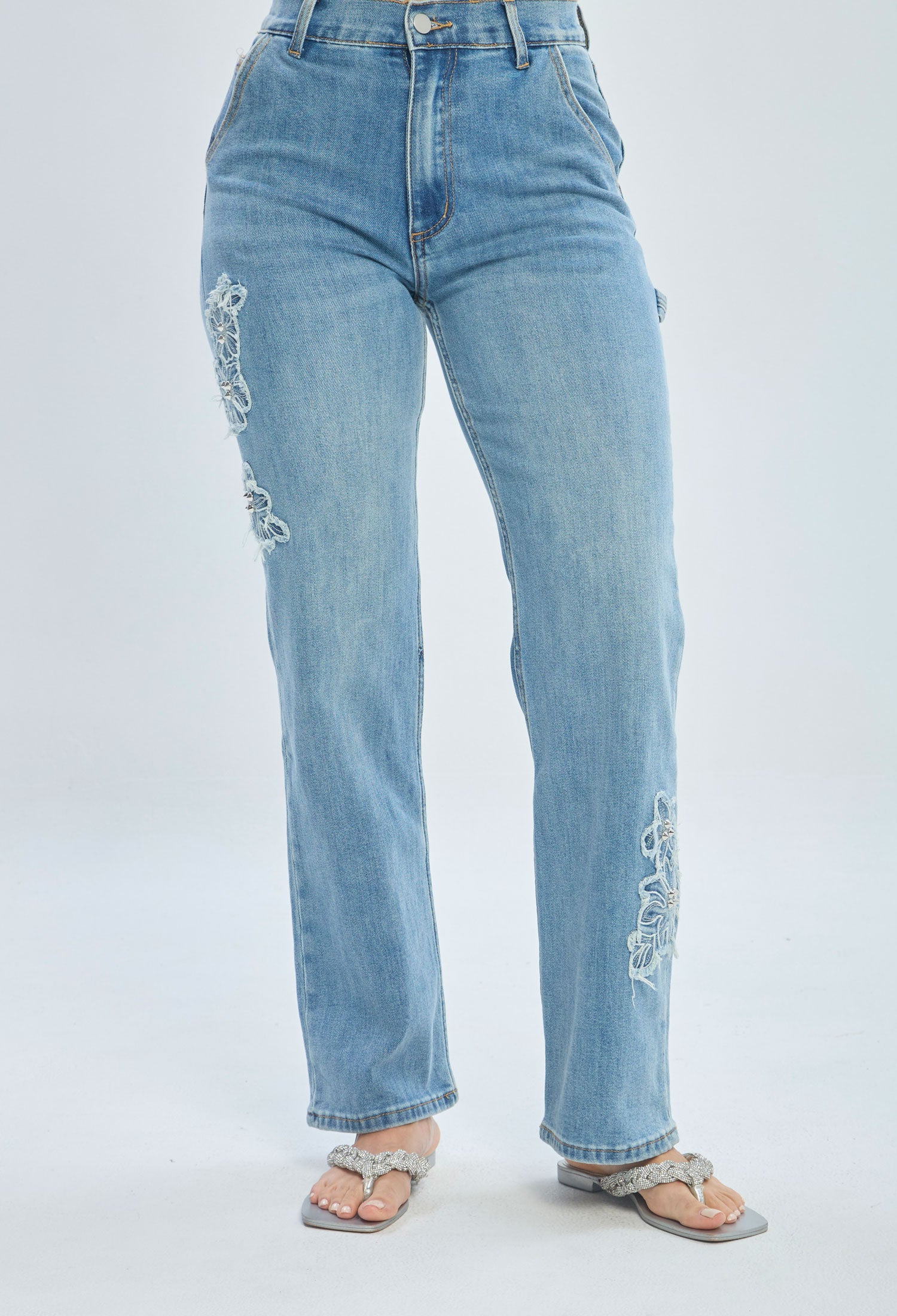 Light blue high waisted jeans with floral embroidery and frayed details, front view