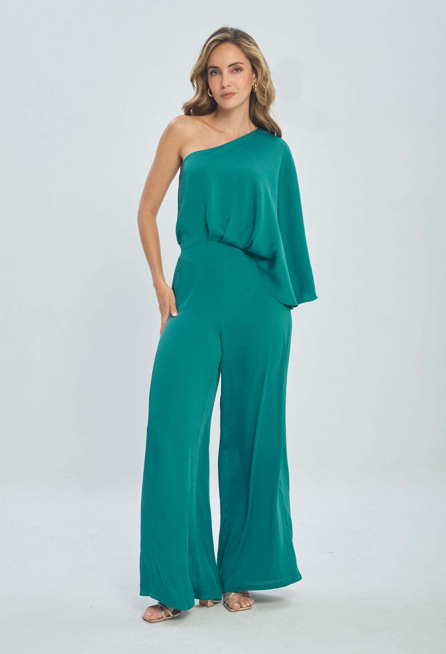 Woman wearing a teal one-shoulder jumpsuit with wide-leg pants, fashion studio shot