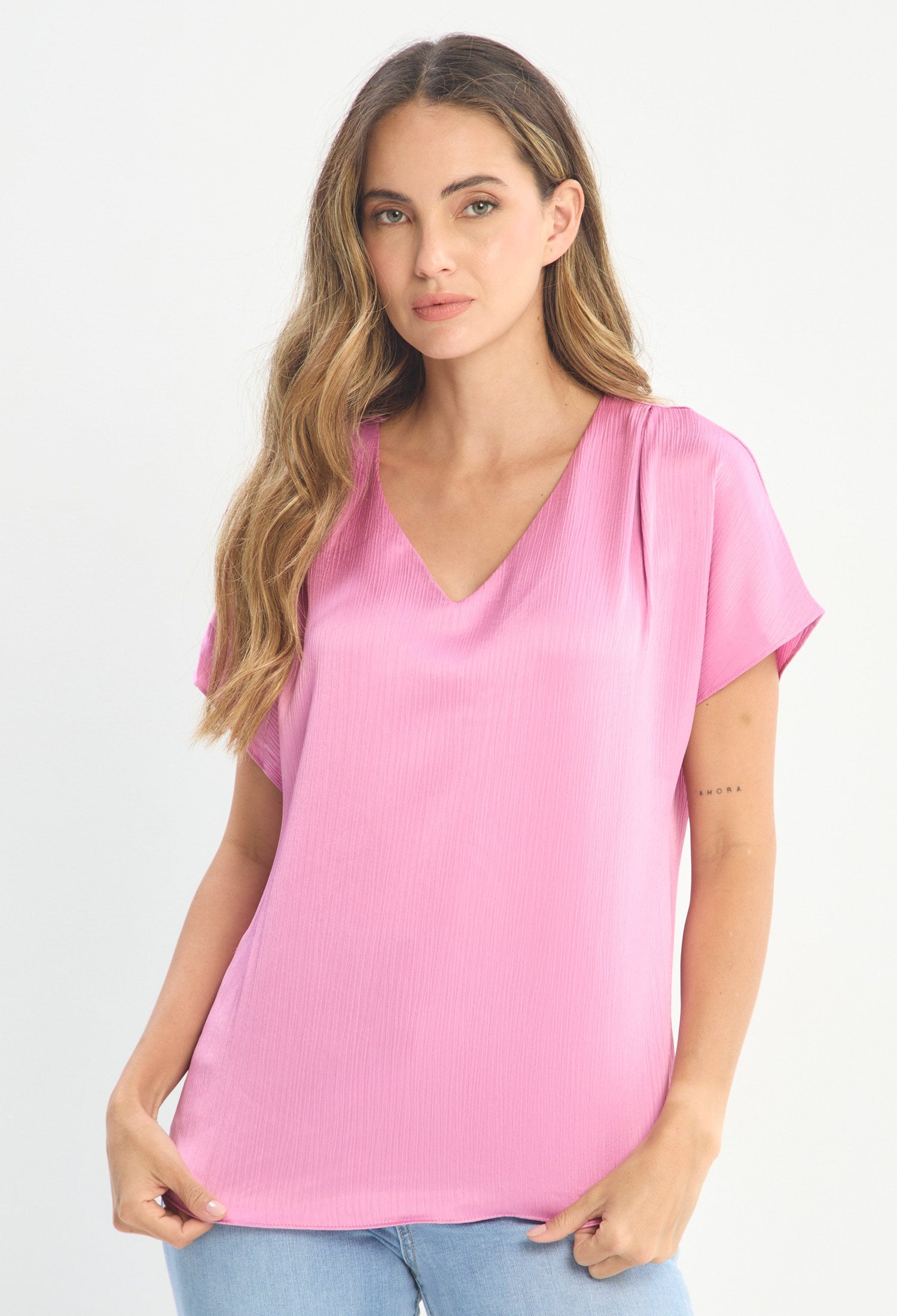 Mujer luciendo blusa rosa BYBLA - Escote V Manga Corta