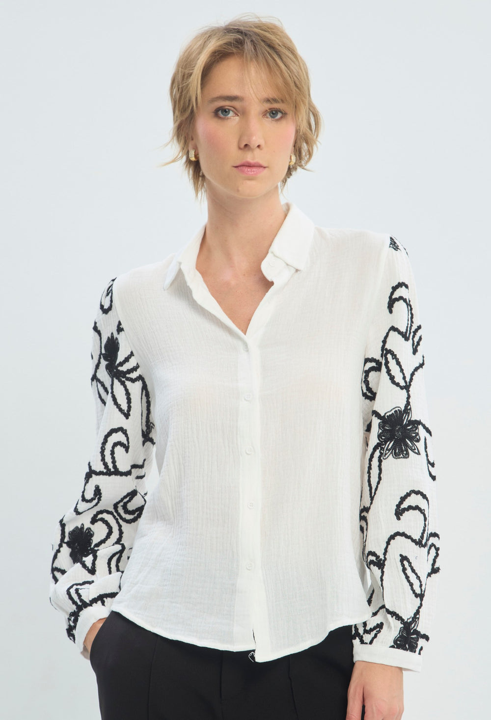 Blusa blanca manga larga con bordado floral negro en las mangas BYBLA