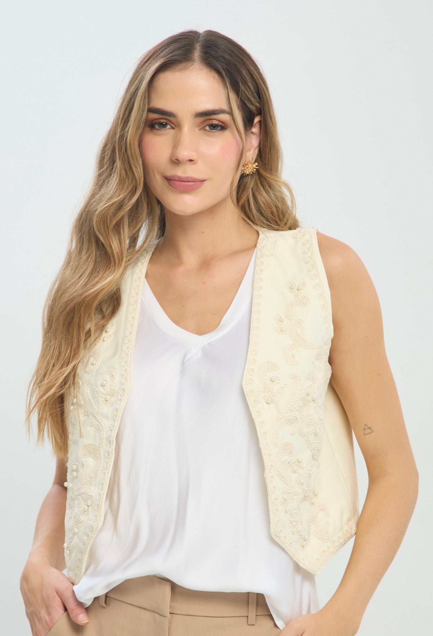 Chaleco beige corto sin mangas con bordado y perlas, abierto al frente