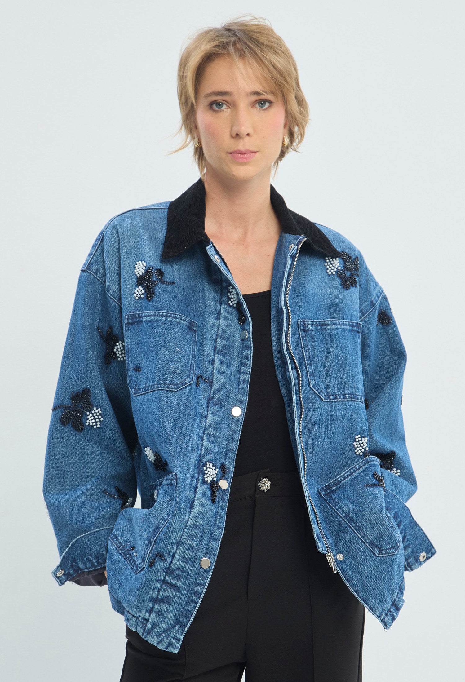Chaqueta de jean azul oversize con cuello en pana negra y flores en pedrería BYBLA